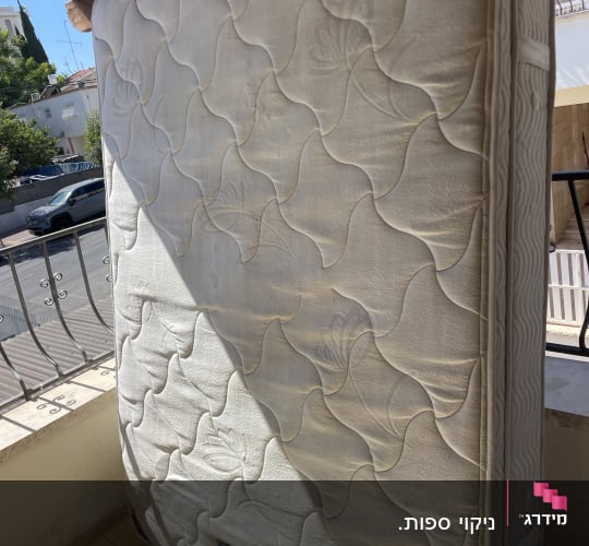 מזרן זוגי עומד במרפסת לייבוש לאחר ניקוי מזרנים